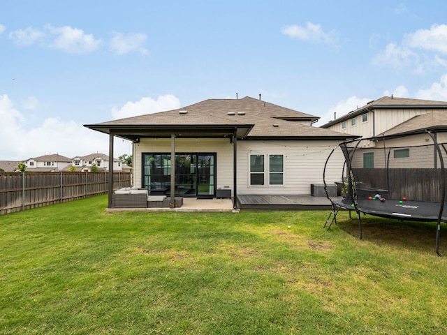453 Arrowhead Vine St, Leander, TX 78641 - back of house featuring a trampoline, a fenced backyard, outdoor lounge area, a deck, and a shingled roof