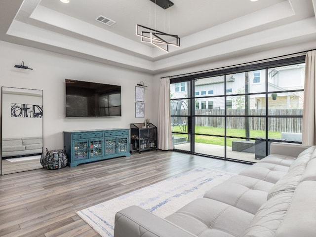 453 Arrowhead Vine St, Leander, TX 78641 - living room featuring a tray ceiling and wood finished floors