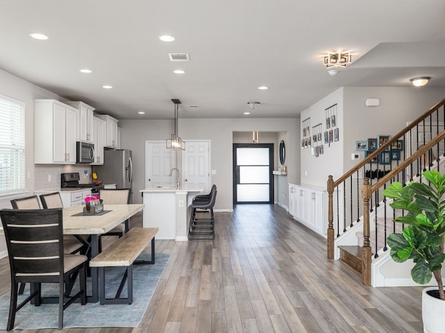 453 Arrowhead Vine St, Leander, TX 78641 - dining space with recessed lighting, wood finished floors, and stairs