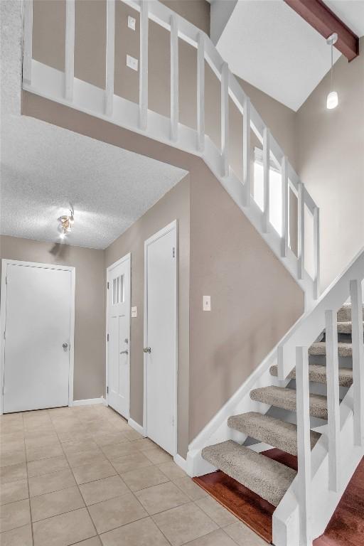 1028 Verbena Dr Unit 1144, Austin, TX 78750 - stairs featuring tile patterned floors and beam ceiling