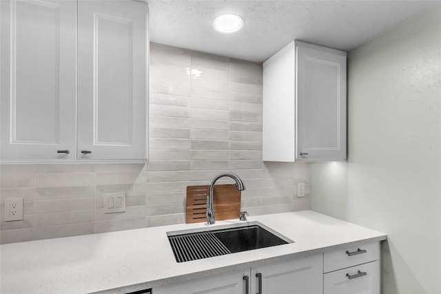 1028 Verbena Dr Unit 1144, Austin, TX 78750 - kitchen with white cabinets, tasteful backsplash, and light stone counters