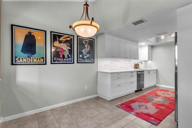 1028 Verbena Dr Unit 1144, Austin, TX 78750 - kitchen featuring stainless steel dishwasher, decorative backsplash, light tile patterned flooring, white cabinetry, and light countertops