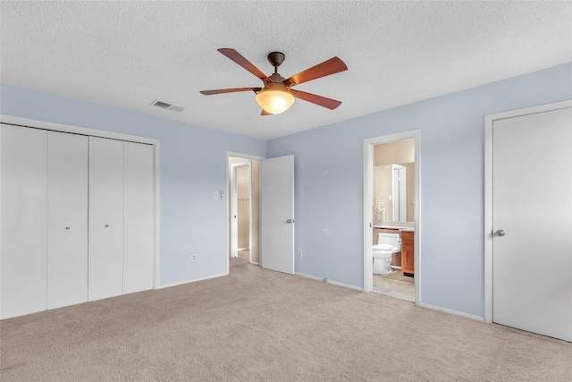 1028 Verbena Dr Unit 1144, Austin, TX 78750 - unfurnished bedroom featuring carpet flooring, a closet, ensuite bath, a textured ceiling, and a ceiling fan