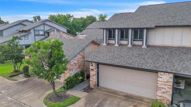 1028 Verbena Dr Unit 1144, Austin, TX 78750 - view of front of home with roof with shingles, board and batten siding, concrete driveway, and brick siding