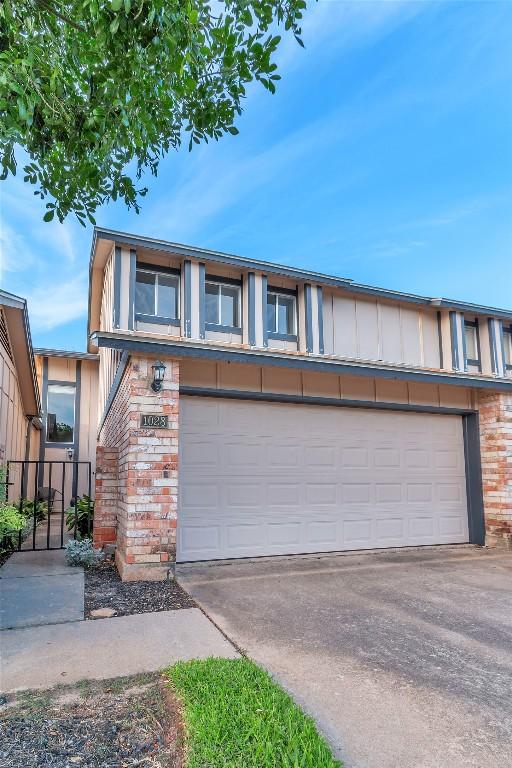 1028 Verbena Dr Unit 1144, Austin, TX 78750 - view of front of home featuring a garage, brick siding, and concrete driveway