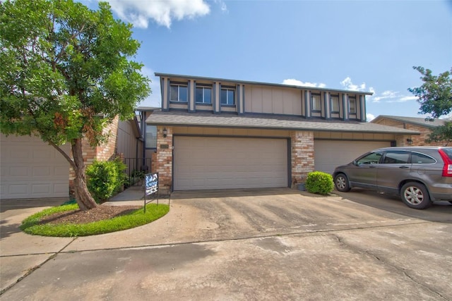 1028 Verbena Dr, Austin, TX 78750 - view of front facade with driveway, a garage, and brick siding