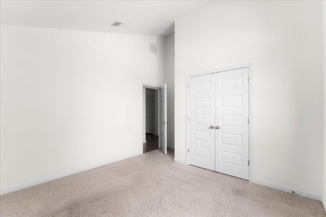 8213 Spire Vw, Austin, TX 78744 - unfurnished bedroom featuring light colored carpet, a closet, and a towering ceiling