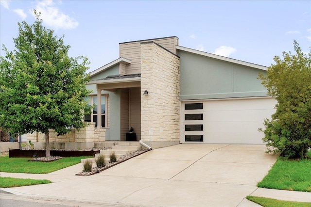 8213 Spire Vw, Austin, TX 78744 - mid-century inspired home with concrete driveway, a garage, stone siding, and stucco siding