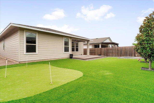 8213 Spire Vw, Austin, TX 78744 - back of house with an area to practice putting and a patio