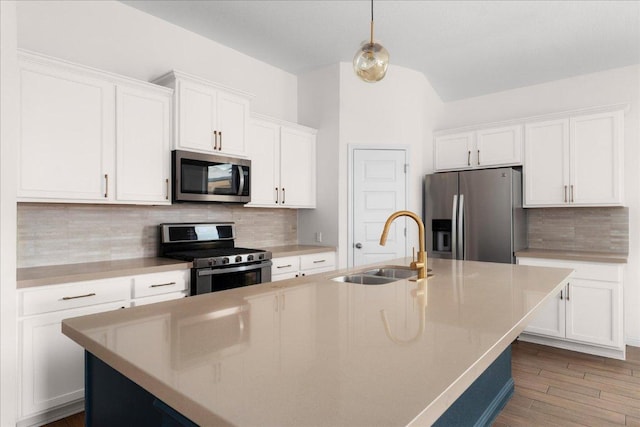 8213 Spire Vw, Austin, TX 78744 - kitchen with stainless steel appliances, a kitchen island with sink, tasteful backsplash, white cabinetry, and dark wood-style flooring