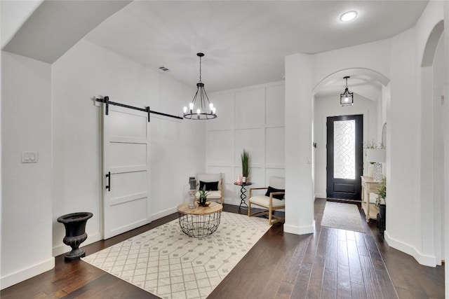239 Holman Path, Hutto, TX 78634 - foyer with arched walkways, a barn door, dark wood finished floors, a chandelier, and recessed lighting