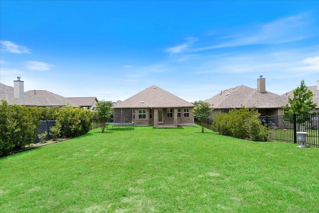2520 Milan Meadows Dr, Leander, TX 78641 - rear view of house with a trampoline, a fenced backyard, and brick siding