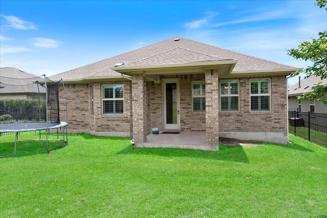 2520 Milan Meadows Dr, Leander, TX 78641 - back of property featuring a trampoline, a patio, brick siding, and roof with shingles