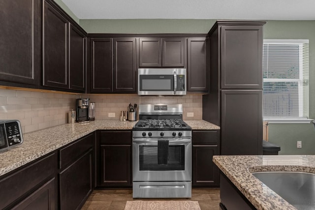 1420 Anhalt Dr Unit 50B, Pflugerville, TX 78660 - kitchen with appliances with stainless steel finishes, decorative backsplash, and light stone countertops