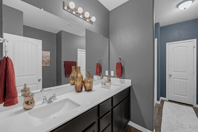 1420 Anhalt Dr Unit 50B, Pflugerville, TX 78660 - full bath with a textured wall, double vanity, and wood finished floors
