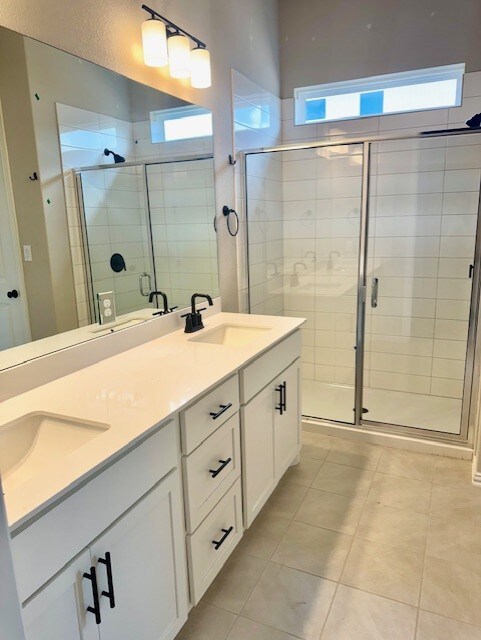370 Milkwood Ter, Dripping Springs, TX 78620 - full bath with a shower stall, double vanity, and tile patterned floors