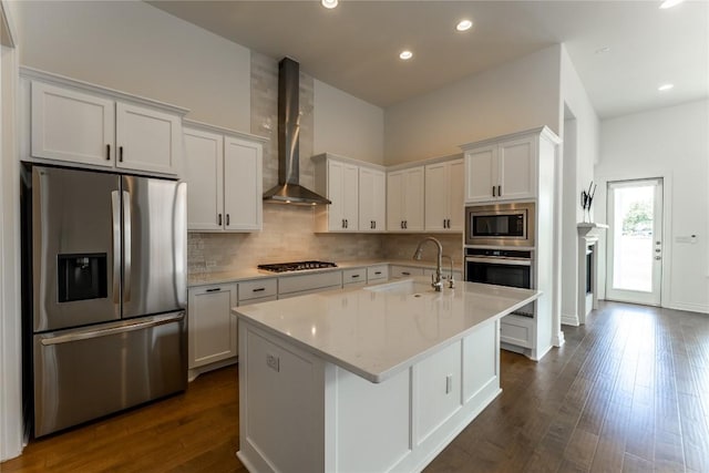 152 Limestone Dr, Georgetown, TX 78628 - kitchen featuring appliances with stainless steel finishes, wall chimney range hood, tasteful backsplash, dark wood-style floors, and white cabinets