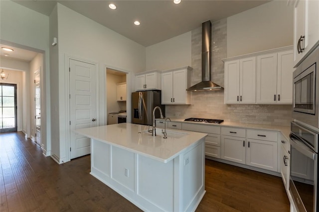 152 Limestone Dr, Georgetown, TX 78628 - kitchen featuring appliances with stainless steel finishes, wall chimney range hood, white cabinetry, backsplash, and recessed lighting