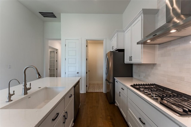 152 Limestone Dr, Georgetown, TX 78628 - kitchen with wall chimney range hood, appliances with stainless steel finishes, decorative backsplash, dark wood-type flooring, and white cabinets
