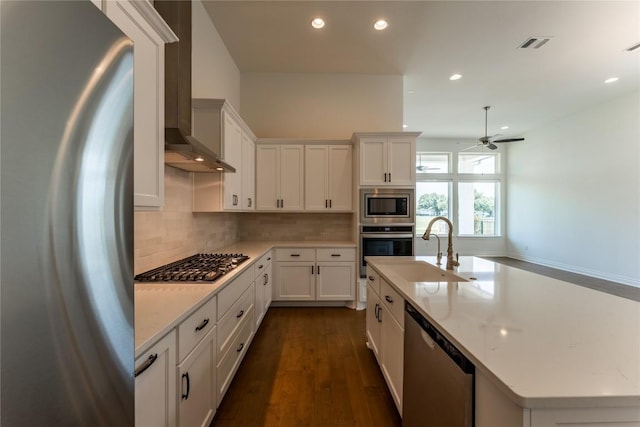 152 Limestone Dr, Georgetown, TX 78628 - kitchen featuring appliances with stainless steel finishes, wall chimney range hood, recessed lighting, decorative backsplash, and ceiling fan