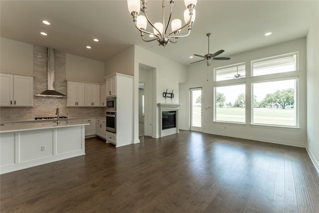 152 Limestone Dr, Georgetown, TX 78628 - kitchen featuring stainless steel appliances, wall chimney range hood, open floor plan, a ceiling fan, and light countertops