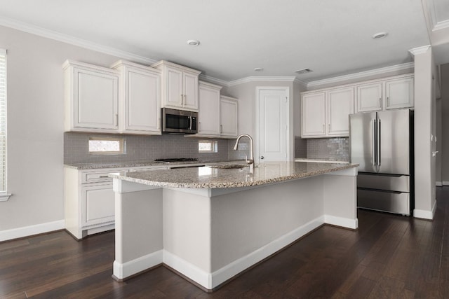 103 County Road 180 Unit 35, Leander, TX 78641 - kitchen with stainless steel appliances, dark wood finished floors, light stone counters, a center island with sink, and decorative backsplash