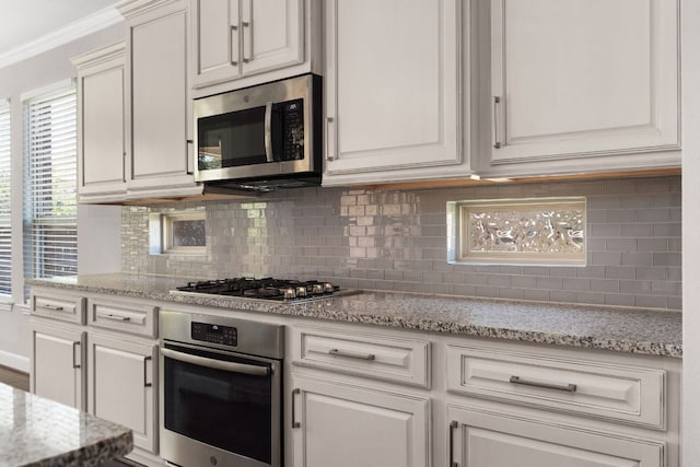 103 County Road 180 Unit 35, Leander, TX 78641 - kitchen with stainless steel appliances, decorative backsplash, white cabinetry, and crown molding