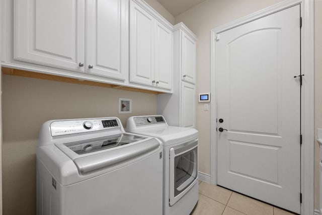 223 Delfino Cir, Austin, TX 78734 - laundry area featuring cabinet space, washer and clothes dryer, and light tile patterned floors