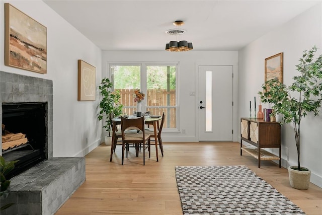 6806 Syracuse Cv, Austin, TX 78723 - entrance foyer featuring light wood-style floors, a tile fireplace, and a chandelier