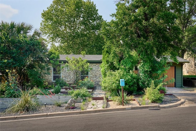 6806 Syracuse Cv, Austin, TX 78723 - view of property hidden behind natural elements featuring stone siding and an outbuilding