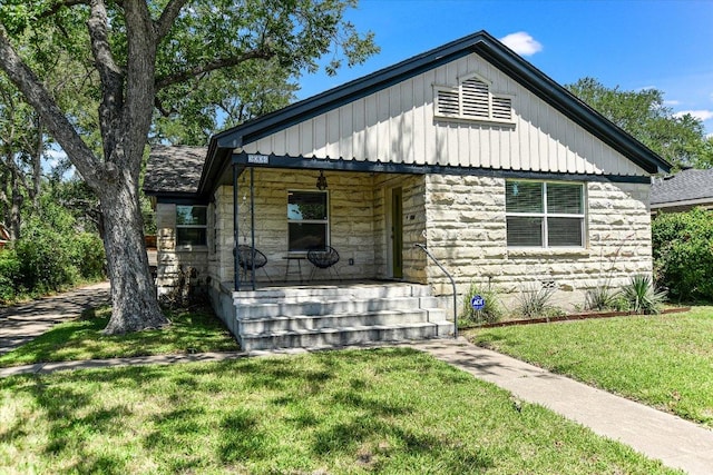 3004 Breeze Ter, Austin, TX 78722 - view of front of home featuring stone siding, covered porch, a front lawn, and board and batten siding
