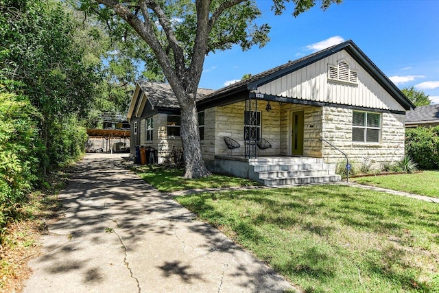 3004 Breeze Ter, Austin, TX 78722 - view of front facade with stone siding, a porch, a front lawn, and board and batten siding
