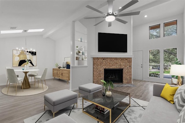 7907 Tealwood Trl, Austin, TX 78731 - living area featuring high vaulted ceiling, a skylight, wood finished floors, a fireplace, and a ceiling fan