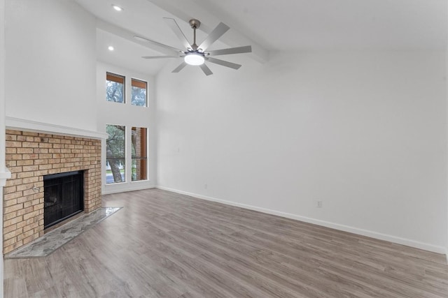 7907 Tealwood Trl, Austin, TX 78731 - unfurnished living room with ceiling fan, high vaulted ceiling, a fireplace, wood finished floors, and recessed lighting