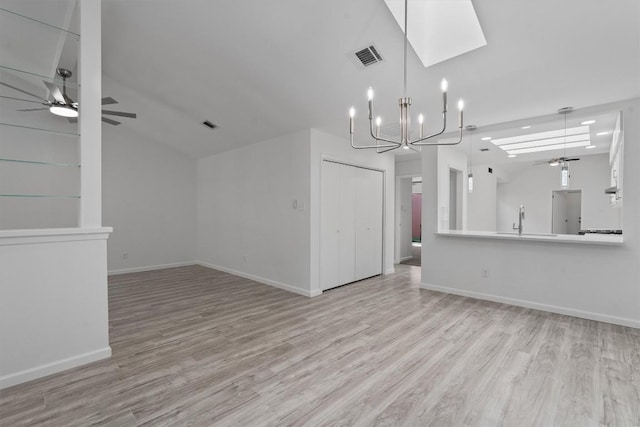 7907 Tealwood Trl, Austin, TX 78731 - unfurnished living room with ceiling fan, light wood finished floors, a skylight, a chandelier, and lofted ceiling