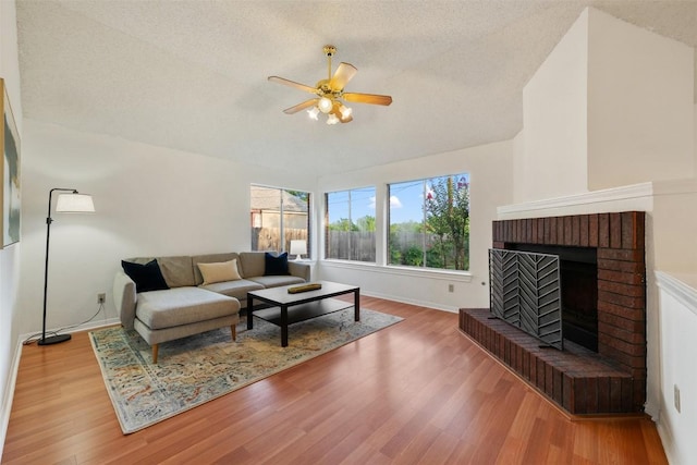 7806 Vail Valley Dr, Austin, TX 78749 - living room with a ceiling fan, wood finished floors, a brick fireplace, and a textured ceiling