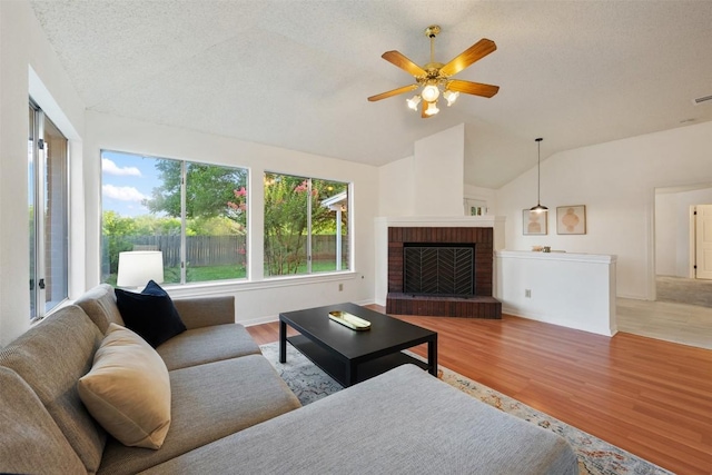 7806 Vail Valley Dr, Austin, TX 78749 - living area with vaulted ceiling, a ceiling fan, wood finished floors, and a fireplace
