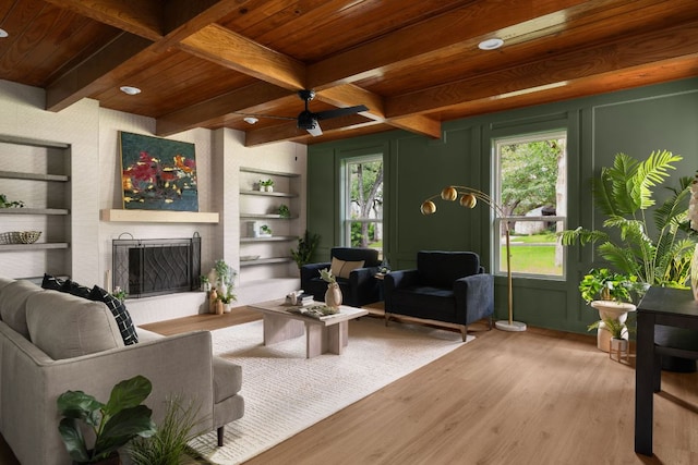 10006 Mandeville Cir, Austin, TX 78750 - living area featuring wood finished floors, built in features, a wood ceiling with exposed beams, a fireplace, and ceiling fan