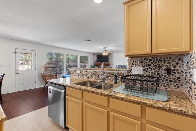 6005 La Mesa St, Leander, TX 78645 - kitchen with stainless steel dishwasher, backsplash, a ceiling fan, light stone counters, and a peninsula