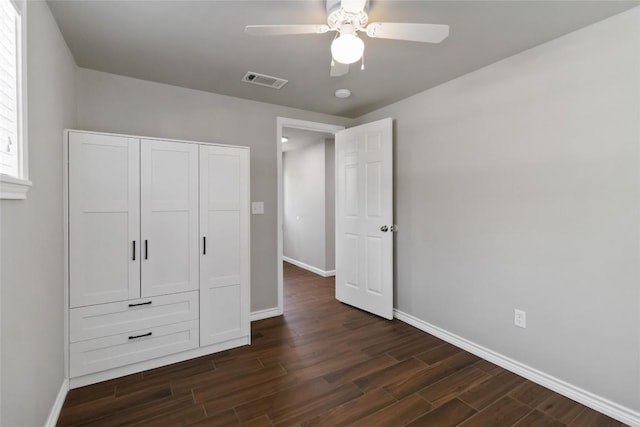 106 Harper Dr, Bastrop, TX 78602 - unfurnished bedroom featuring dark wood finished floors, a closet, and ceiling fan