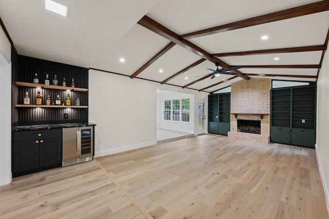 8909 Laurel Grove Dr, Austin, TX 78758 - indoor bar featuring beverage cooler, light wood-type flooring, a ceiling fan, a brick fireplace, and recessed lighting