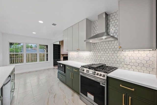 8909 Laurel Grove Dr, Austin, TX 78758 - kitchen with wall chimney range hood, appliances with stainless steel finishes, green cabinetry, light countertops, and recessed lighting