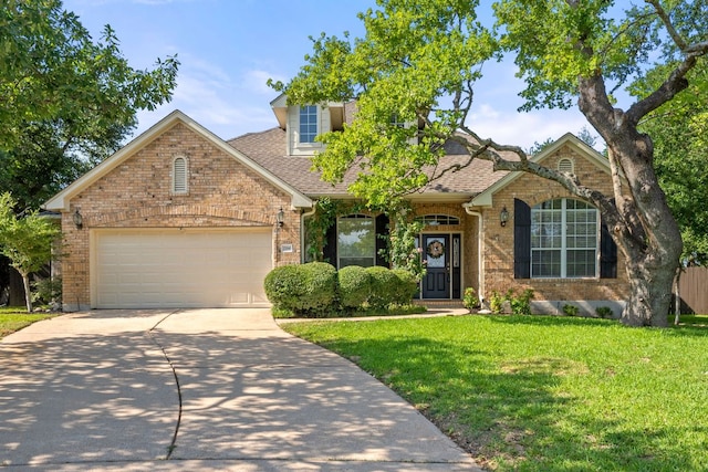 2700 Dagama Ct, Cedar Park, TX 78613 - view of front of house with concrete driveway, a front lawn, an attached garage, brick siding, and a shingled roof