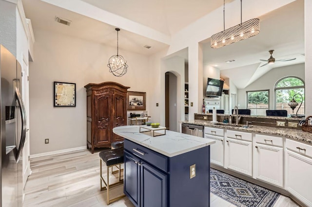 4231 N Summercrest Loop, Round Rock, TX 78681 - kitchen with arched walkways, ceiling fan, appliances with stainless steel finishes, white cabinetry, and light wood-type flooring