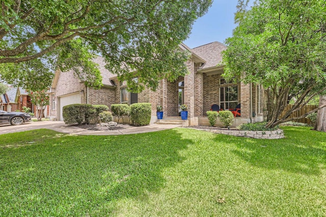 4231 N Summercrest Loop, Round Rock, TX 78681 - obstructed view of property with an attached garage, brick siding, a front lawn, roof with shingles, and driveway