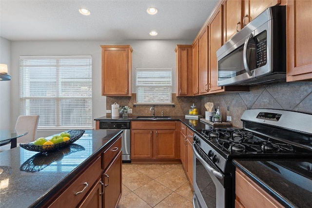 11221 Old Quarry Rd, Austin, TX 78717 - kitchen featuring stainless steel appliances, decorative backsplash, light tile patterned floors, dark stone countertops, and recessed lighting