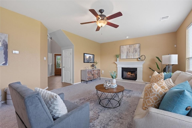 11221 Old Quarry Rd, Austin, TX 78717 - carpeted living room with ceiling fan, a lit fireplace, and tile patterned floors