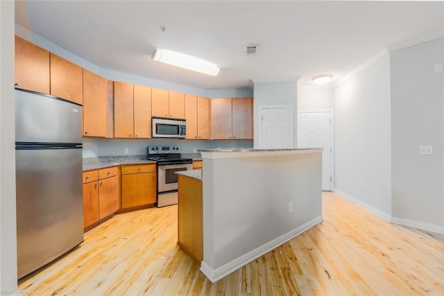 2502 Leon St Unit 305, Austin, TX 78705 - kitchen featuring appliances with stainless steel finishes, light wood-type flooring, ornamental molding, a kitchen island, and light stone countertops