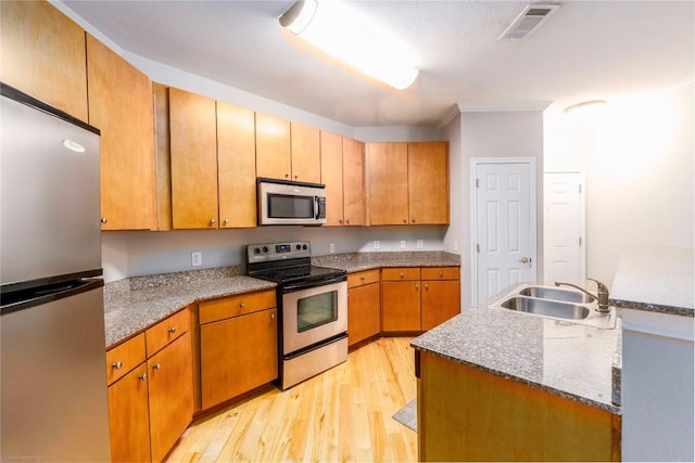 2502 Leon St Unit 305, Austin, TX 78705 - kitchen featuring appliances with stainless steel finishes, light wood-style floors, and crown molding