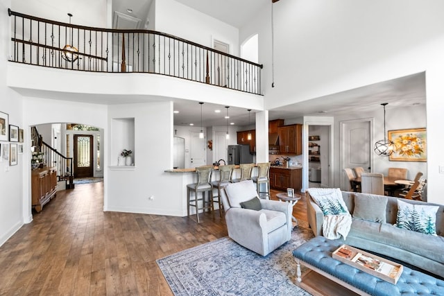 174 Jayne Cv, Austin, TX 78737 - living area with hardwood / wood-style flooring, stairs, a towering ceiling, and arched walkways